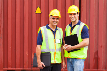 shipping company workers standing in front of containers