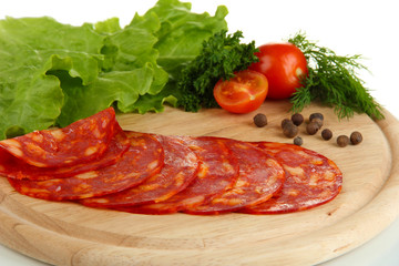 Salami slices on wooden board, close up