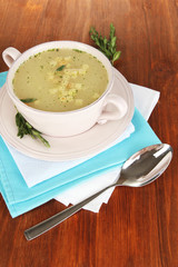 Nourishing soup in pink pan on wooden table close-up