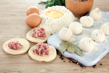 Raw dumplings, ingredients and dough, on wooden table
