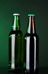 Bottles of beer on green background