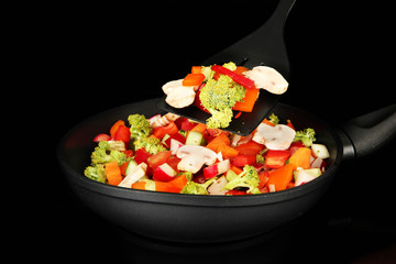 Vegetable ragout in pan, isolated on black