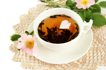 Cup of herbal tea with hip rose flowers, isolated on white