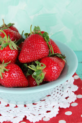 Strawberries in plate on napkin on blue background