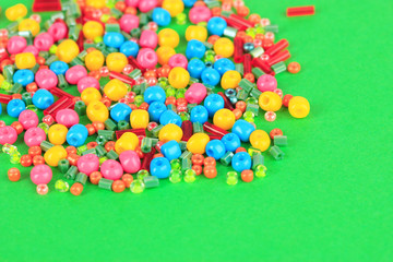 Fototapeta premium Different colorful beads on green background
