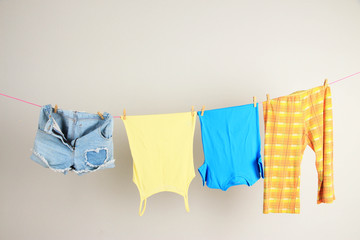 Laundry line with clothes on wall background