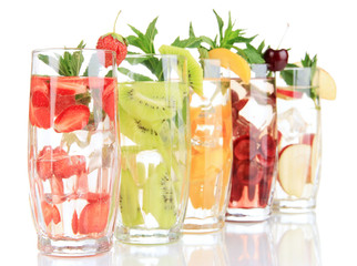 Glasses of fruit drinks with ice cubes isolated on white