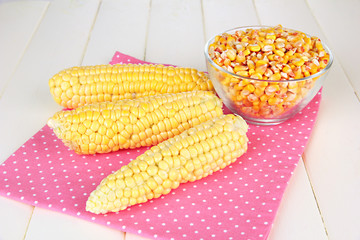 Fresh and dried corn on wooden background