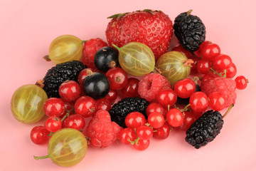 Ripe berries on pink background