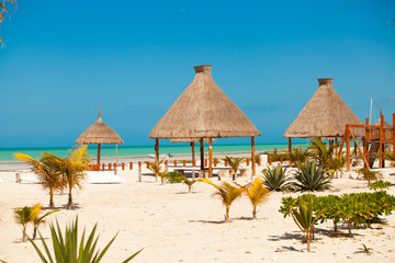 Luxury hotel at tropical resort on ocean shore with palm trees