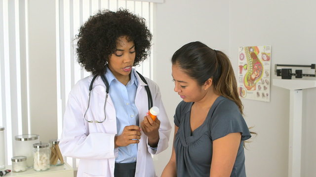 Female multiracial doctor giving prescription to her patient