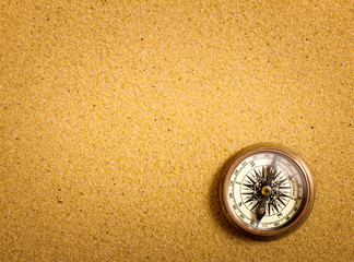 Compass on sand background