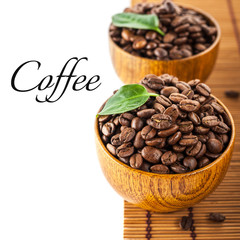 Dark roasted coffee beans in wooden bowl