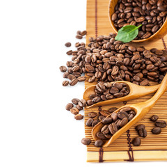 Coffee beans in a wooden scoop on the table
