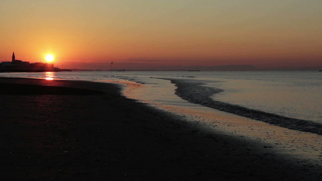 sunrise over the sea with church silhouette