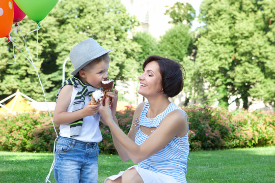 Happy mother and little son with ice-creams outdoors