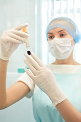 Medical doctor woman looking on test tube with blood