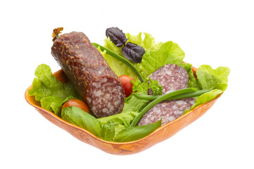 Ripe salami with salad, basil, onion and tomato