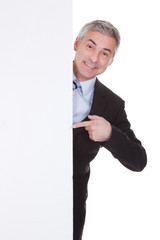 Mature Businessman Pointing At Placard