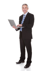 Happy Mature Businessman Using Laptop