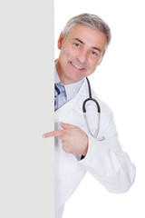 Portrait Of Male Doctor Holding Placard