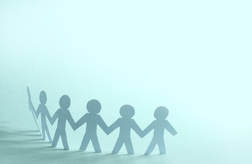 Team of paper doll people holding hands
