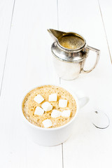 Cup of cappuccino with foam, marshmallow, cinnamon and milk mug
