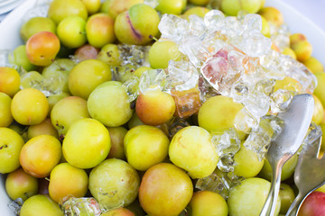 Fresh natural ripe plums with ice cubes