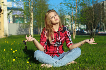 Blonde girl meditating on grass