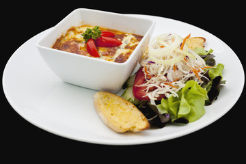 Homemade beef lasagna with salad.