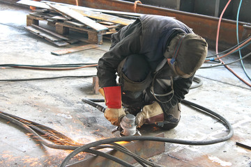 Worker is cutting metal by grinder