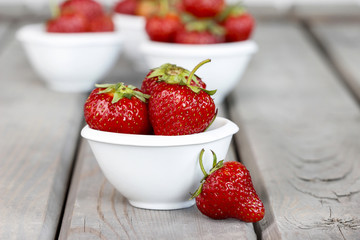 Fresh ripe strawberries in white ceramic bowl