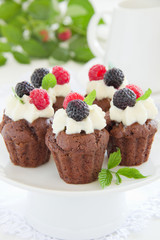 Chocolate muffins with raspberries and cream.