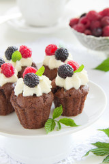Chocolate muffins with raspberries and cream.