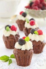 Chocolate muffins with raspberries and cream.