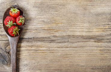 Strawberries on wooden spoon. Copy space.