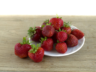 ripe red strawberries is located on wooden board