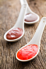 various barbecue sauces in ceramic spoons