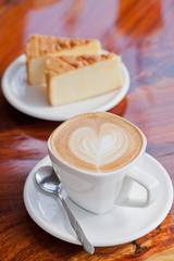 Cup of latte coffee with cake