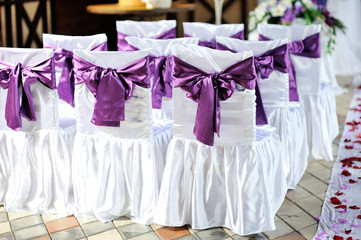 Fototapeta na wymiar The chairs are decorated with purple bows