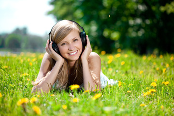 Beautiful smiling woman Woman listening to music on headphones o