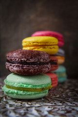 Colorful french macaroons on dark wooden background