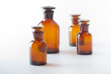 Small chemical glass bottles on white background