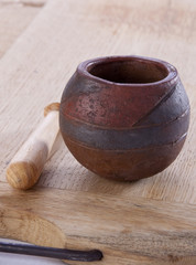 Traditional Moroccan pestle and mortar on wood background.