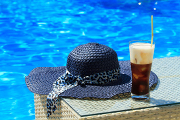 Ice coffee Fredo against blue clear water of the swimming pool
