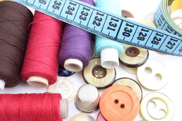 Colorful spools of thread, tape measure, thimble and buttons