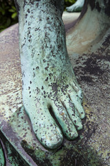 foot on old bronze statue