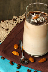 Glass of chocolate-cream cocktail on wooden table close-up