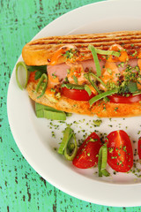 Delicious hot dog on plate on wooden table close-up