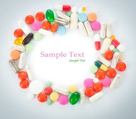 Colored pills, tablets and capsules on a white background